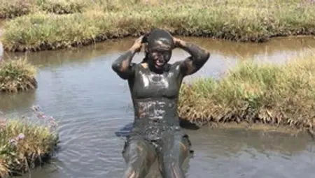 Sexy Girl Playing In The River Mud. Muddy Fun (Fully Clothed)