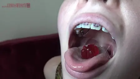 Blue- Eyed Golden-haired With Braces Is Licking And Eating Gummy Bears In A Very Hot Way