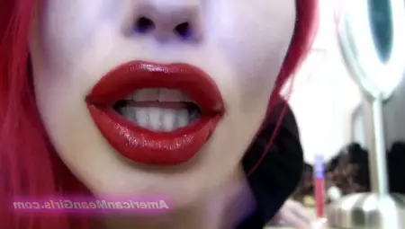 Young Woman With Red Hair Puts Red Lipstick On And Kisses The Camera