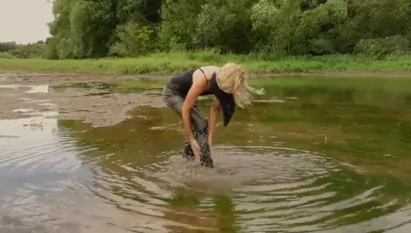 Leggy Blonde With Long Sexy Boots Is Walking In A Mud